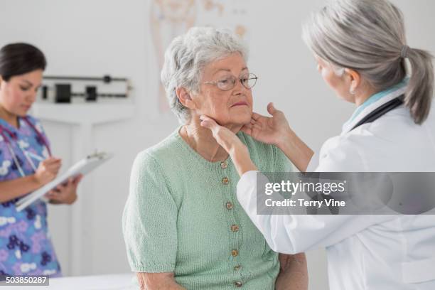 doctor examining patient's glands in office - thyroid exam stock pictures, royalty-free photos & images