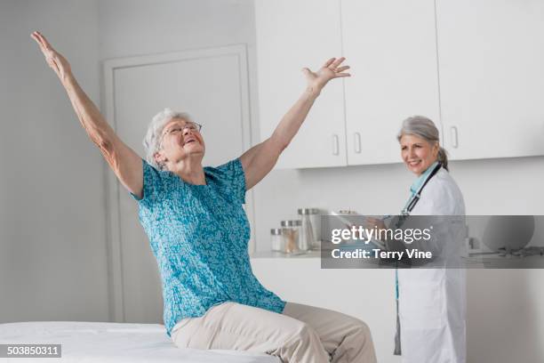 woman cheering in doctor's office - old lady cheering stock-fotos und bilder