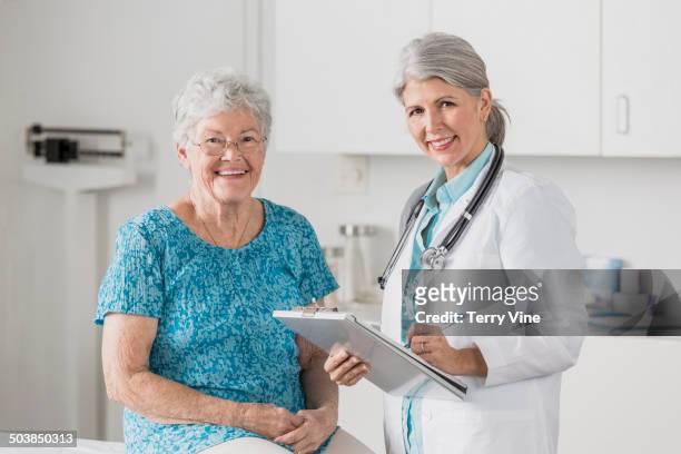 doctor and patient smiling in office - patientin stock-fotos und bilder