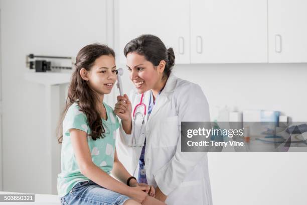 doctor checking patient's ears in hospital - otoscope stock pictures, royalty-free photos & images