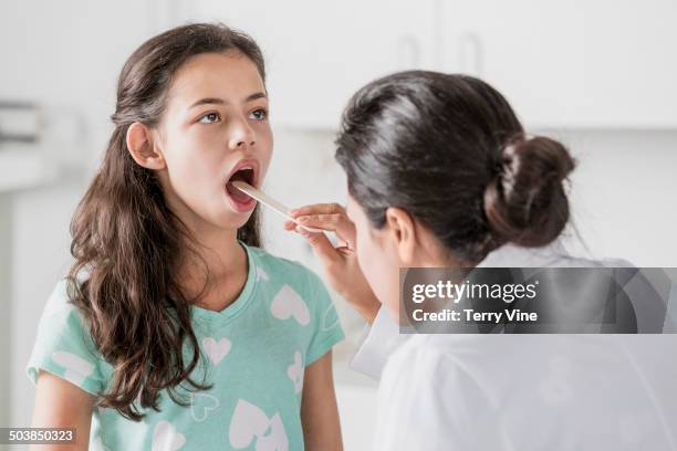 doctor checking patient's tongue in hospital - girl tongue doctor stockfoto's en -beelden