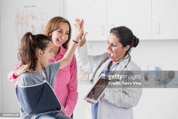 doctor and patient high fiving in office - kind mit armschlinge stock-fotos und bilder