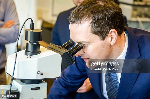 Chancellor of the Exchequer George Osborne inspects a microchip using a microscope during his visit to the Cardiff School of Physics and Astronomy...