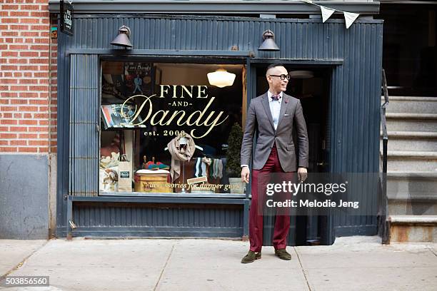 Enrique Crame of Fine And Dandy shop wears TVR OPT 501 black frames glasses, a Coffee Suit Blazer by Massimo Dutti, bow tie, pocket square, and...