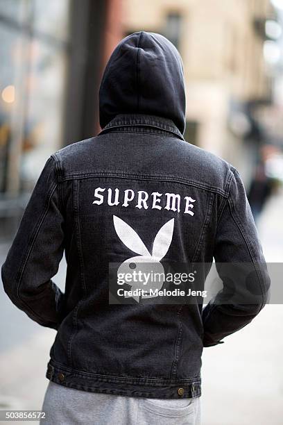 Shopper wears a Supreme x Playboy black denim jacket outside the Supreme store in Soho on December 01, 2015 in New York City.