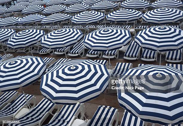 blue and white striped beach umbrellas - rayas marineras fotografías e imágenes de stock
