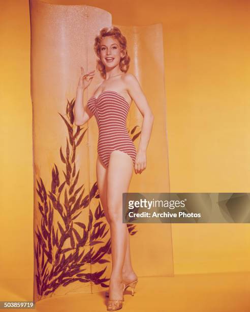 American actress Barbara Eden wearing a striped swimming costume, circa 1959.