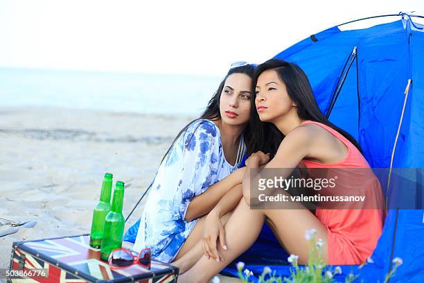 girls looking the sky on beach - skybox stockfoto's en -beelden