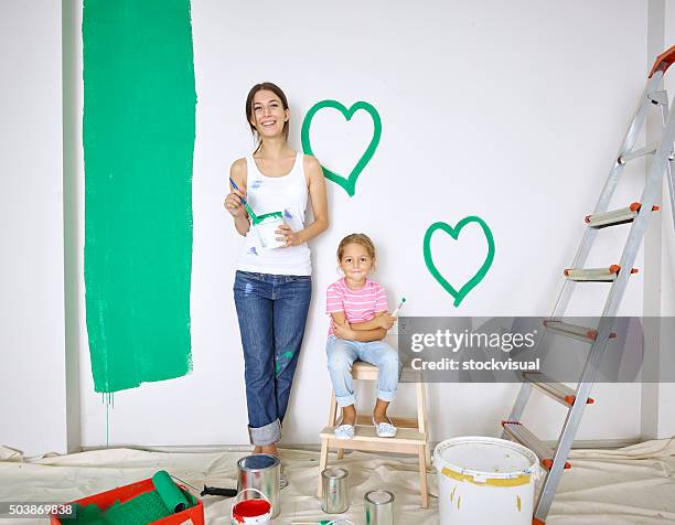 mother and daughter painting green hearts on wall - kid leaning stock pictures, royalty-free photos & images