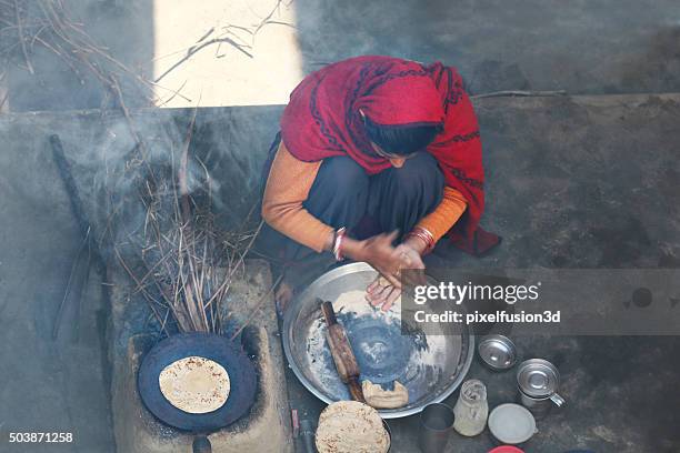 rural women making chapatti on wood burning stove (chulha) - india women stock pictures, royalty-free photos & images