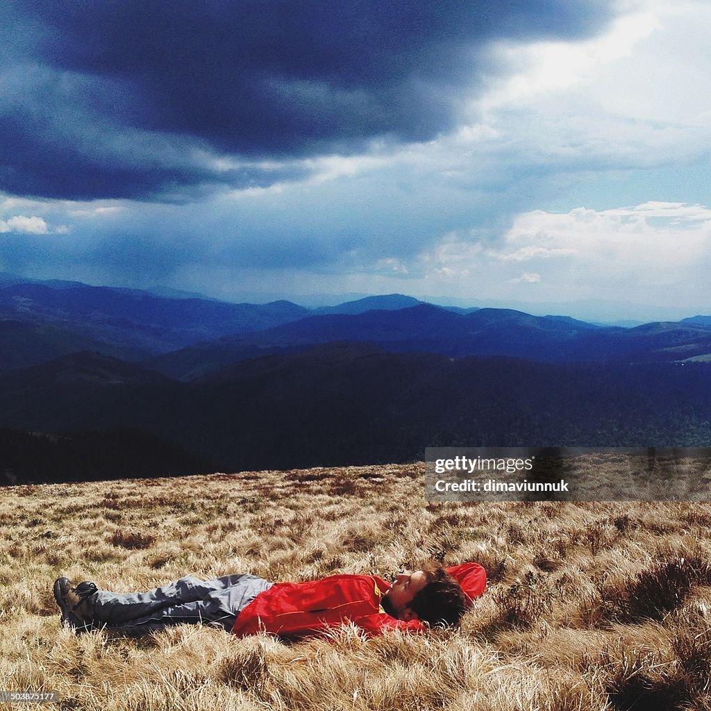 Man lying in grass in remote landscape