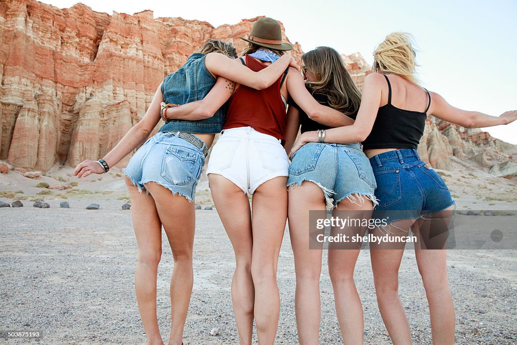 Rear view of four women wearing denim shorts