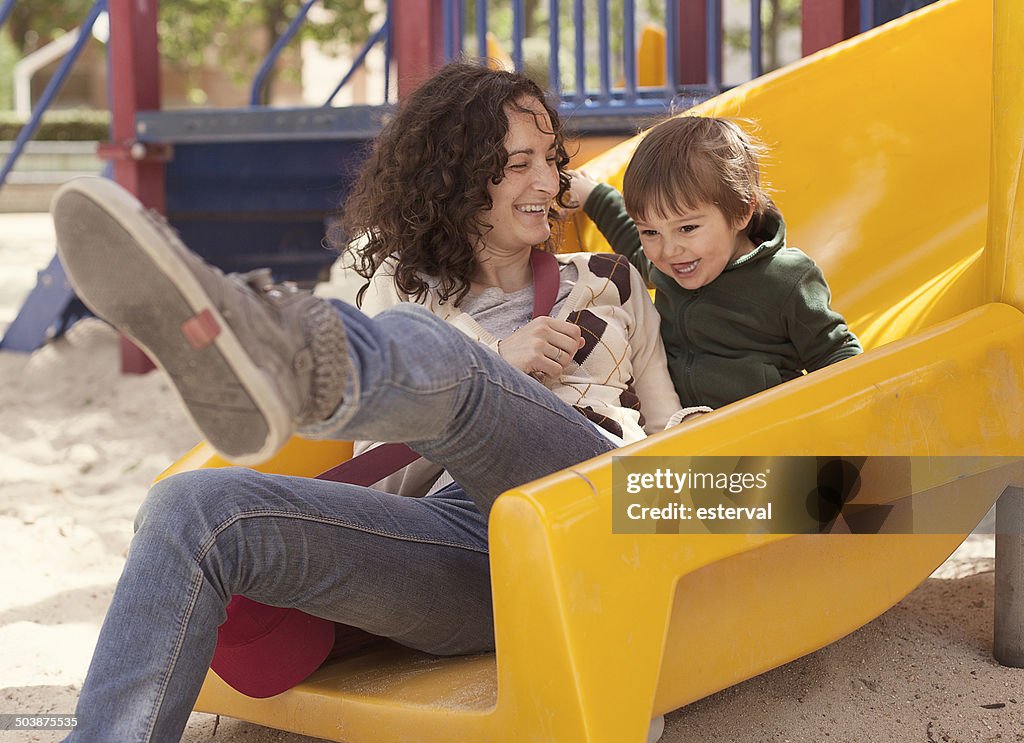 Mother and son on a slide in playground