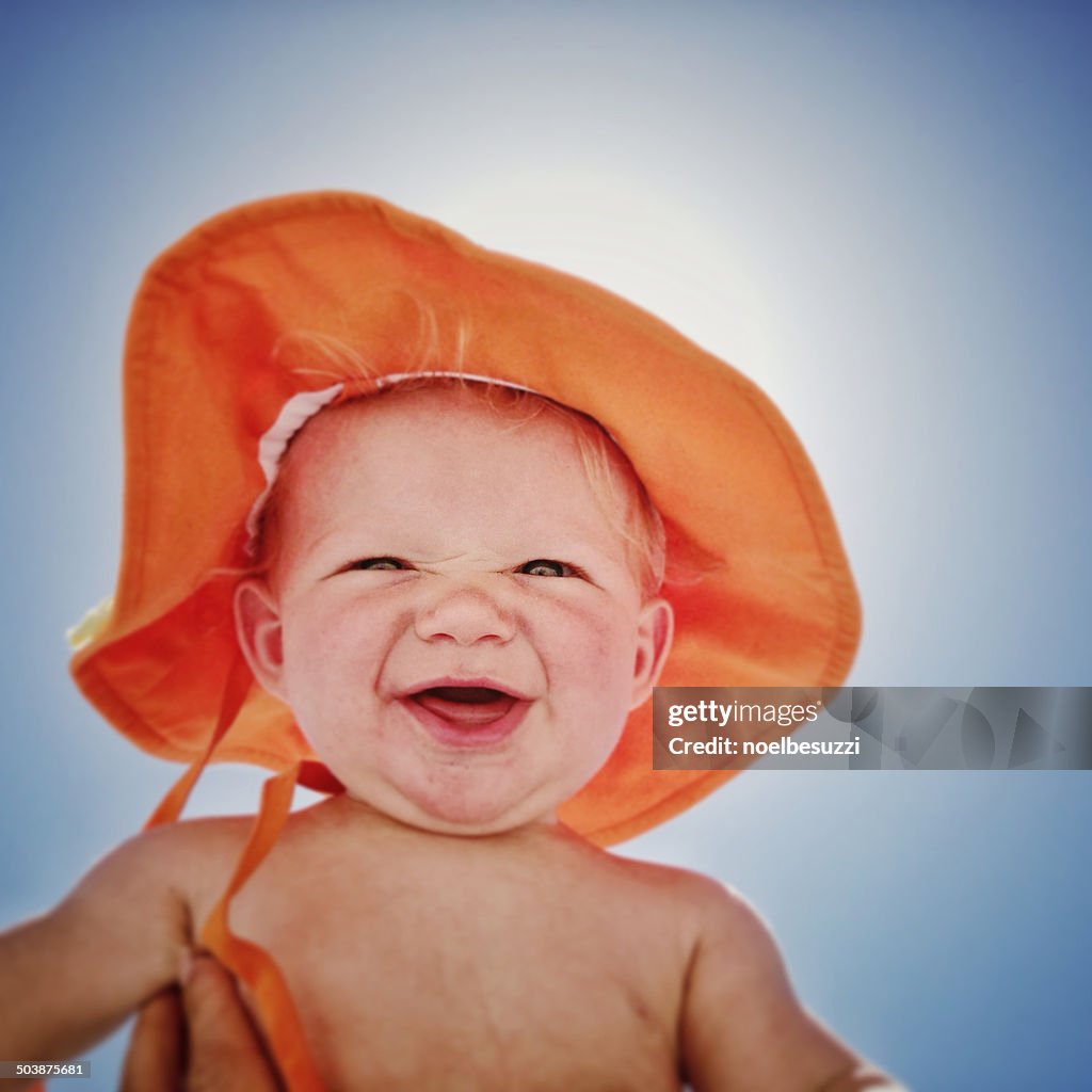 Boy on beach wearing a sun hat