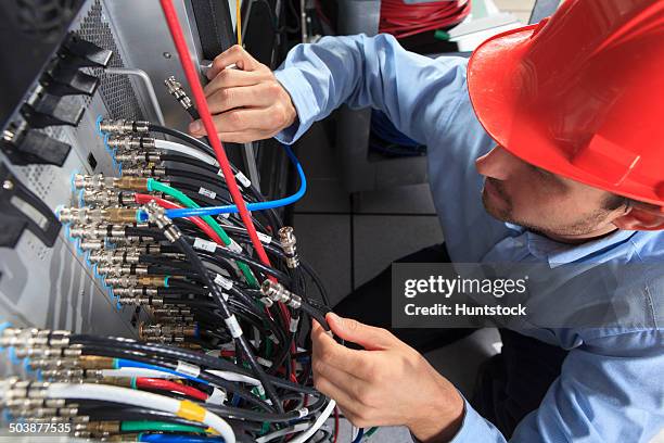 network engineer holding bnc cable connection at patch panel - tomada de ligação à rede imagens e fotografias de stock