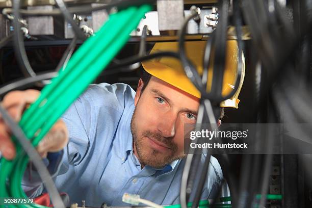 network engineer bundling cable for structured cabling - fibre optique photos et images de collection