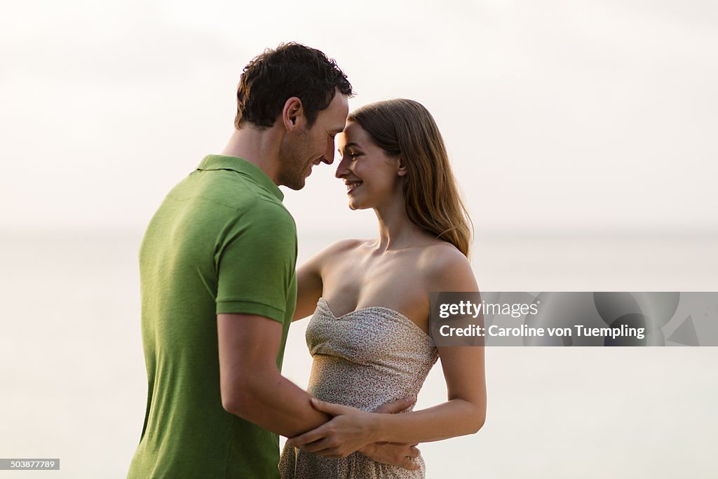 Happy young couple embracing by the sea