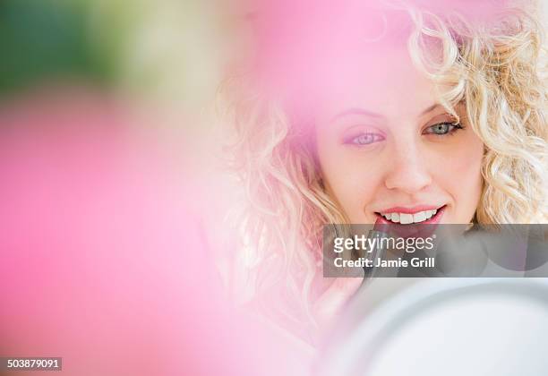 young woman applying lipstick - rosa lippenstift stock-fotos und bilder
