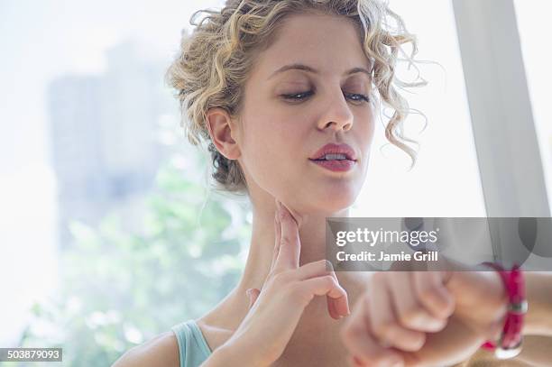 woman taking her pulse - prendre le pouls photos et images de collection