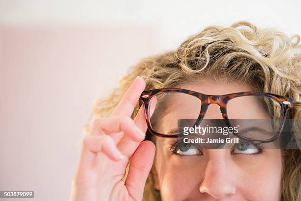 woman wearing glasses, looking up in thought - spectacles stock pictures, royalty-free photos & images