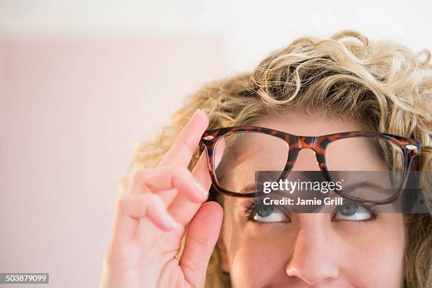 woman wearing glasses, looking up in thought - spectacle imagens e fotografias de stock