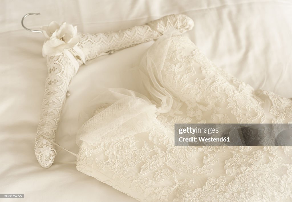 Germany, Lace wedding dress lying on bed