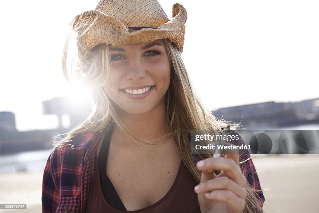 Portrait of smiling young woman wearing cowboy hat