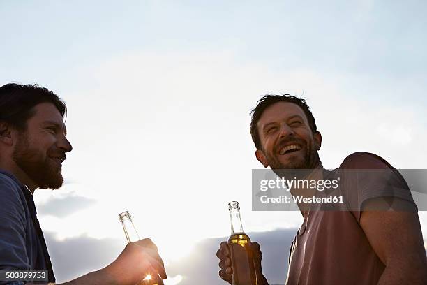 two friends with beer bottles outdoors - cologne bottle stock pictures, royalty-free photos & images