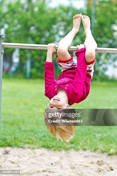 little girl hanging head first at bar - horizontal bar stock pictures, royalty-free photos & images