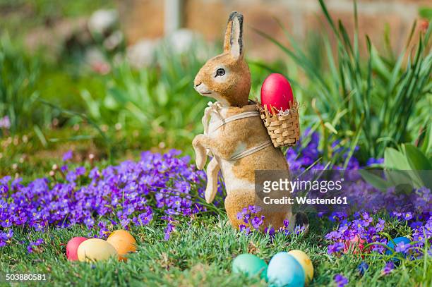 easter bunny in garden with flowers - 庭の置物 ストックフォトと画像