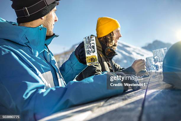 austria, vorarlberg, riezlern, two skiers in beer garden - ski closeup stock-fotos und bilder