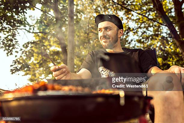 germany, hannover, man having a barbecue - lower saxony stock pictures, royalty-free photos & images