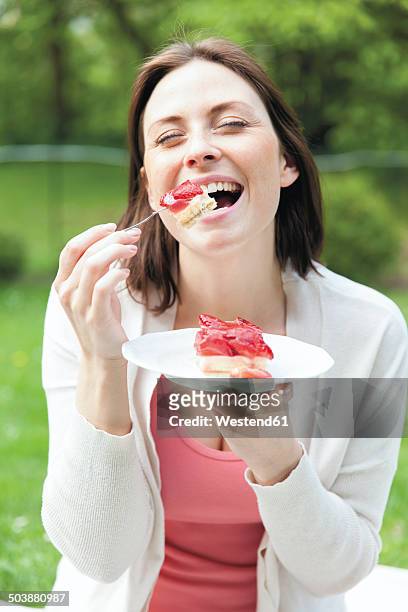 portrait of young woman enjoy eating strawberry cake - cake photos et images de collection