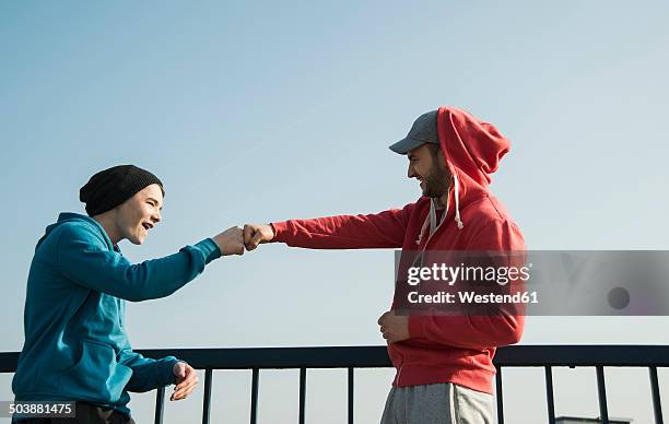 young man and teenager at railing under blue sky - blue sky friends photos et images de collection