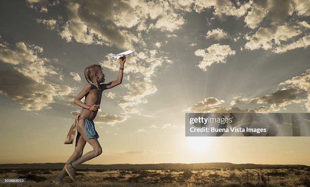 Himba girl playing wit a toy airplane