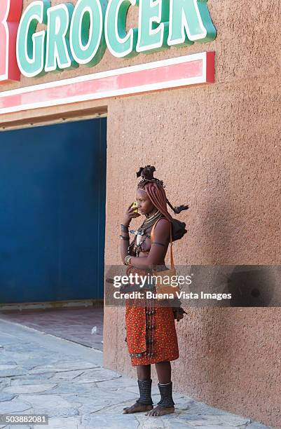 himba woman with cell phone. - opuwo tribe stock-fotos und bilder