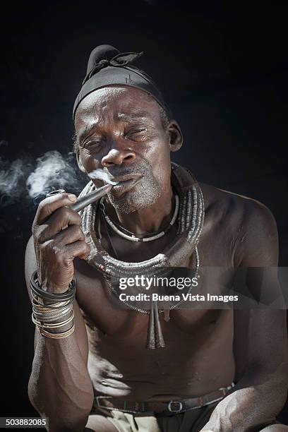 himba man smocking  pipe - opuwo tribe foto e immagini stock