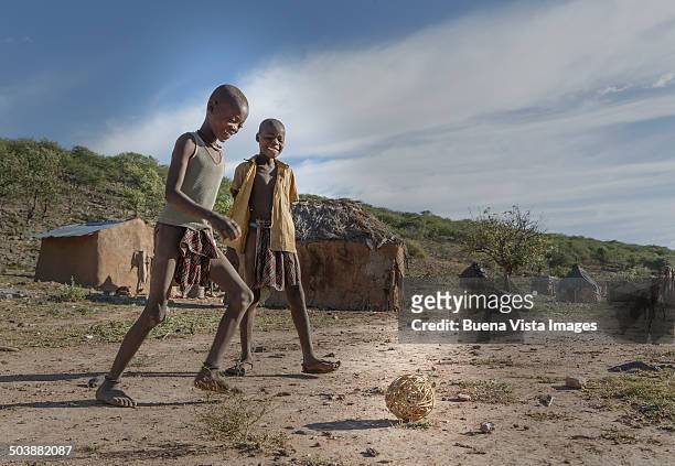african boys playing soccer with a rough ball - opuwo stock pictures, royalty-free photos & images