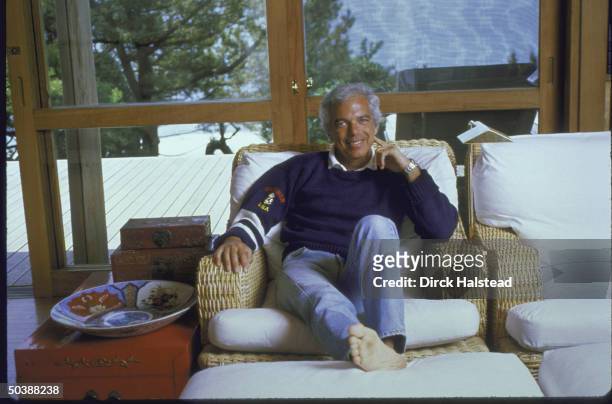 Fashion Designer Ralph Lauren relaxed and sitting on couch in his home.