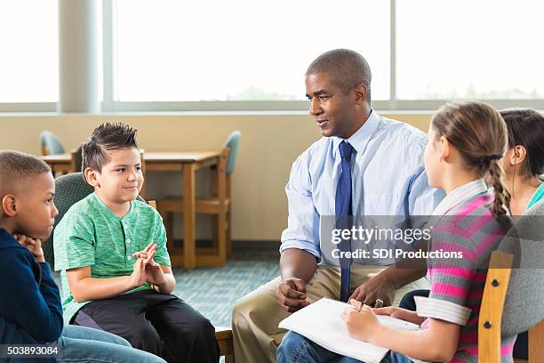 diverse elementary students meeting with counselor after school - bullying adults stock pictures, royalty-free photos & images