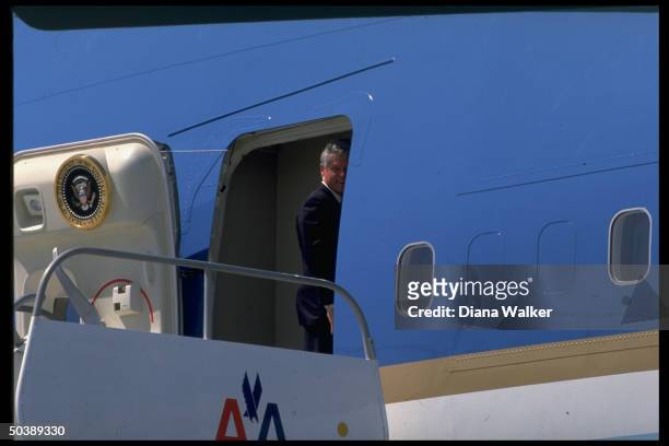 Pres. Bill Clinton turning to smile while boarding Air Force One, winding up visit to Fort Benning.