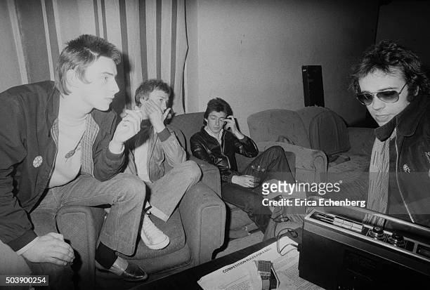 The Jam are interviewed by a journalist backstage at the Royal College of Art, London, 29th April 1977. L-R Paul Weller, Rick Buckler, Bruce Foxton.