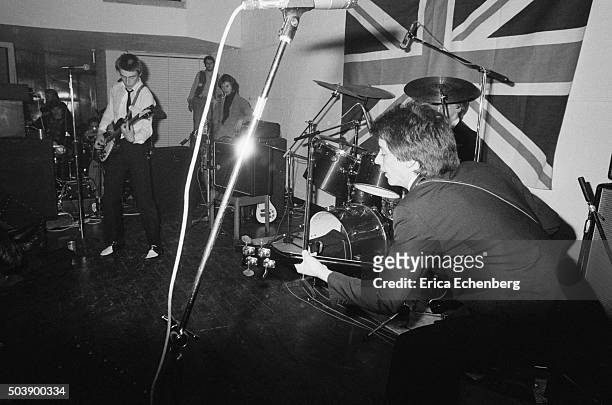 The Jam perform on stage at the Royal College of Art in front of a large Union Flag, London, 29th April 1977. L-R Paul Weller, Bruce Foxton.