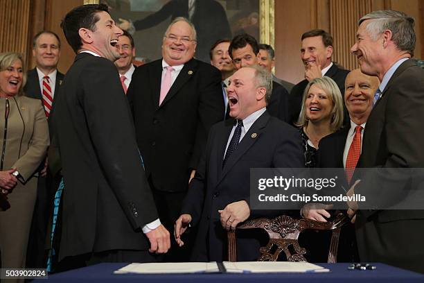 Speaker of the House Paul Ryan shares a laugh with Republican members of Congress after signing legislation to repeal the Affordable Care Act, also...