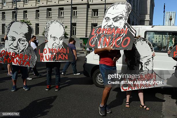 Group of former employees of the Kirchner Cultural Centre hold portraits of Hernan Lombardi, head of the Sistema Federal de Medios y Contenidos...