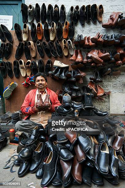 a shoe cobbler surrounded by all his shoes - abundance stock-fotos und bilder