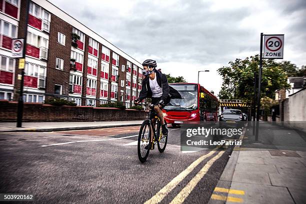 cyclist commuter wearing a pollution-mask in central london - london pollution stock pictures, royalty-free photos & images