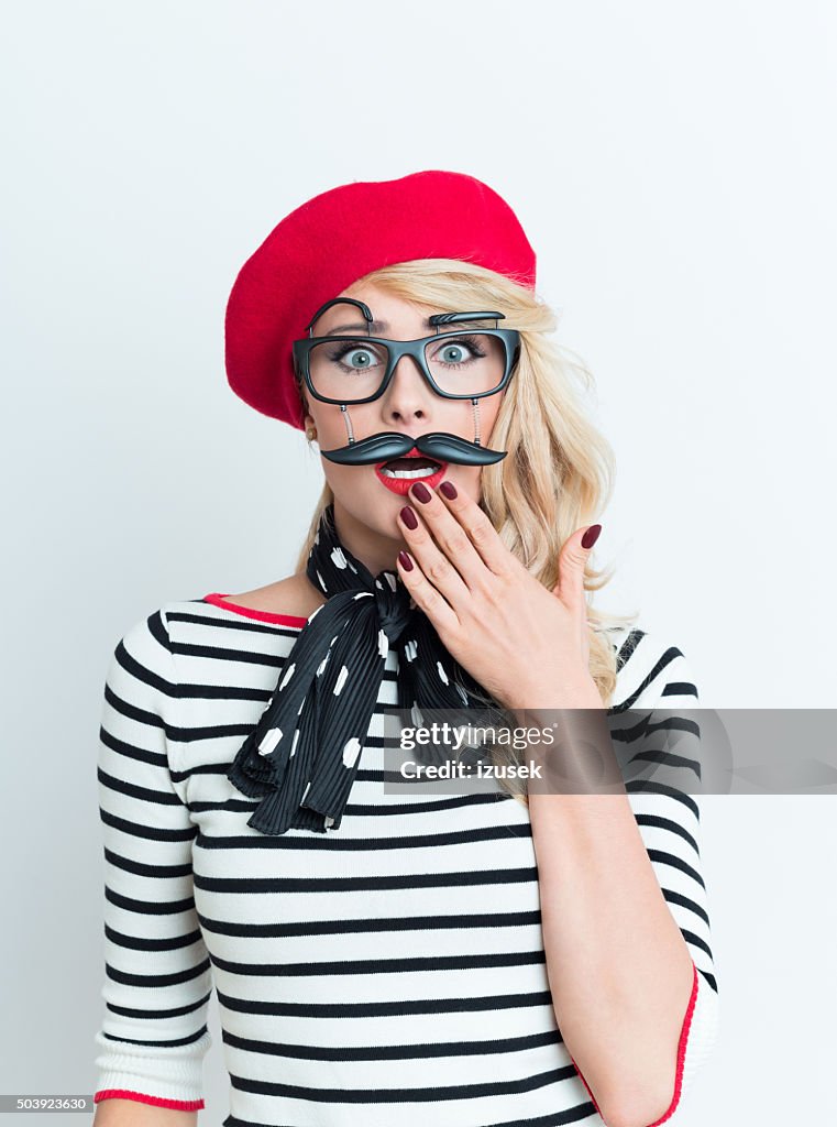 Choqué femme blonde avec rouge français béret et masque pour le visage