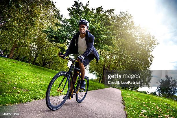 commuter cycling in the park going at work in london - london bikes stock pictures, royalty-free photos & images