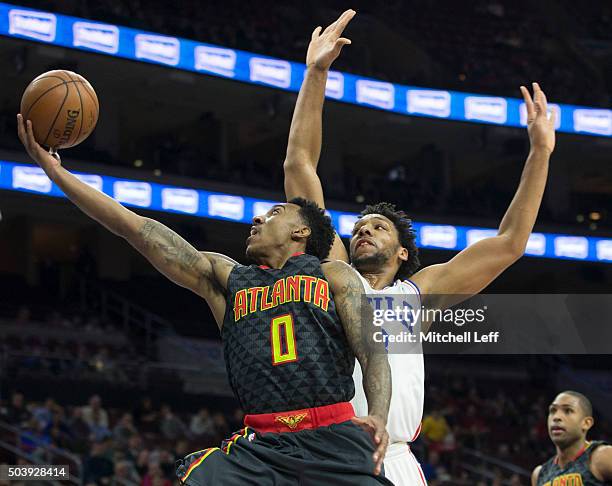 Jeff Teague of the Atlanta Hawks attempts a layup past Jahlil Okafor of the Philadelphia 76ers on January 7, 2016 at the Wells Fargo Center in...
